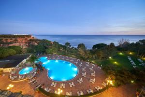 an overhead view of a pool with chairs and the ocean at PortoBay Falesia in Albufeira