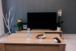 a living room with a tv and a coffee table with a remote control at Amphitrite Beach House in Agios Nikolaos