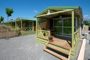 a row of green mobile homes with a deck at Camping Villasol in Benidorm
