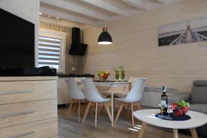 a kitchen and dining room with a table and chairs at Domki Całoroczne Perła in Mrzeżyno