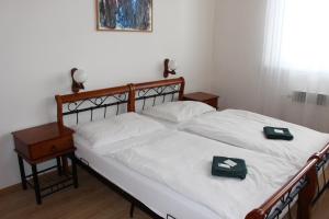 ロウニにあるHotel Černý kůňのベッドルーム1室(白いシーツと木枠のベッド1台付)