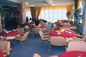 a room with tables and chairs with red table cloths at Ermionida in Kranidi
