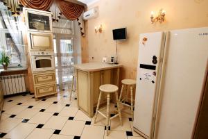 a kitchen with a refrigerator and a table and stools at Апартаменты возле Вокзала, Центр in Dnipro