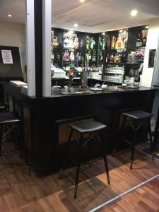 a bar with three stools in front of it at The Gordon House Hotel in Rochester