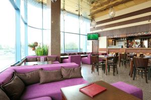 restauracja z fioletowymi kanapami i stołami oraz bar w obiekcie Park Tower w Moskwie
