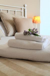 a stack of towels with flowers on a bed at Frasteva in Aci Castello