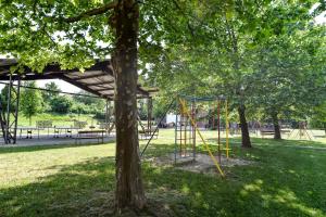 a park with a swing set and a tree at Oliver Inn Camping in Balatonlelle