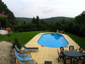 a swimming pool with chairs and a table at Villa Blanka in Horní Podkozí