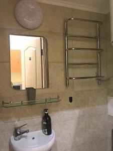 ein Bad mit einem Waschbecken und einem Spiegel in der Unterkunft Apartament at Park in Lwiw