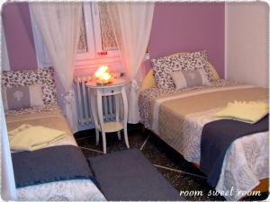 a bedroom with two beds and a table with a candle at Room sweet Room in Bologna