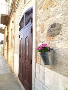 eine Tür zu einem Gebäude mit einem Eimer Blumen in der Unterkunft Oltre le mura b&b in Bitonto