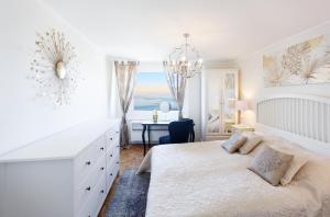 a white bedroom with a bed and a desk at Elegant Apartment with Stunning Lake View in Montreux
