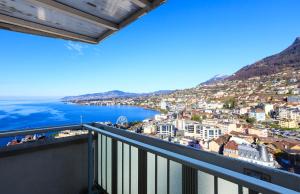a view of a city from a balcony at Elegant Apartment with Stunning Lake View in Montreux