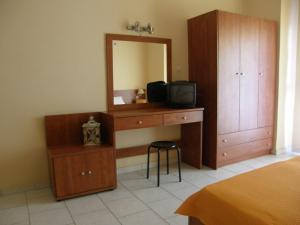 um quarto com uma cómoda, uma televisão e um espelho. em Hotel Aki em Loutra Edipsou