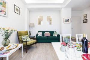 ein Wohnzimmer mit einem grünen Sofa und einem Tisch in der Unterkunft Villa Cavalletti Appartamenti in Grottaferrata