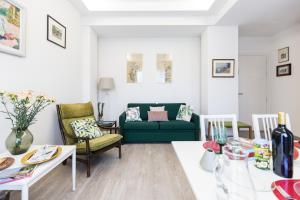 a living room with a green couch and a table at Villa Cavalletti Appartamenti in Grottaferrata