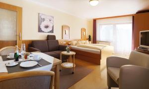 um quarto de hotel com uma cama e uma sala de estar em Appartementhaus Safferstetten em Bad Füssing