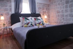 a bedroom with a bed with pillows and a window at Alberto Apartment in Dubrovnik