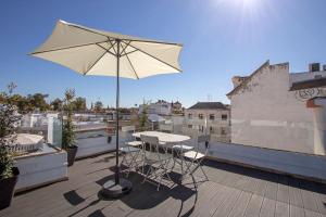 een patio met een tafel en een parasol op een dak bij Cathedral Private Pool Penthouse in Sevilla