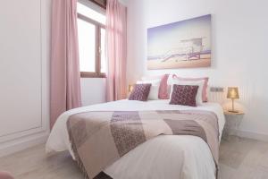 een slaapkamer met een groot wit bed en roze gordijnen bij Cathedral Private Pool Penthouse in Sevilla