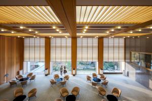 um átrio com cadeiras e mesas e janelas grandes em Hotel Okura Kobe em Kobe