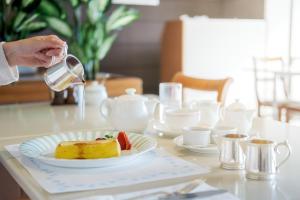 une personne verse de l'eau sur un morceau de gâteau sur une table dans l'établissement Hotel Okura Kobe, à Kobe