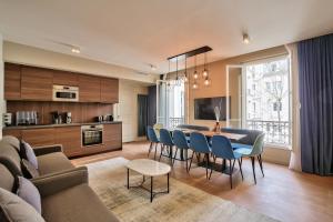 ein Wohnzimmer und eine Küche mit einem Tisch und Stühlen in der Unterkunft 75 - Paris Assas Flat in Paris