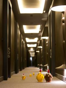 Une rangée de canards en caoutchouc marchant dans un couloir dans l'établissement Monument Hotel, à Barcelone