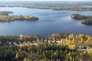 an aerial view of a lake with trees and houses at Luoman Hirvimökit in Ähtäri