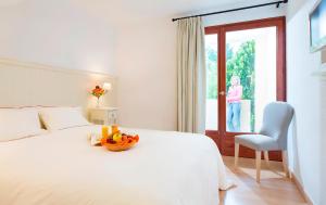 - une chambre avec un lit et une corbeille de fruits dans l'établissement Le Roussillon, à Amélie-les-Bains-Palalda