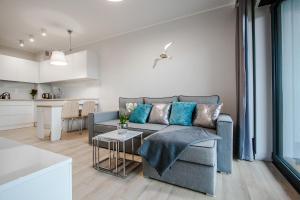 a living room with a couch and a table at Apartamenty Studio Gardenia in Dziwnów
