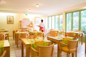 une personne debout dans un restaurant avec des tables et des chaises dans l'établissement Le Roussillon, à Amélie-les-Bains-Palalda