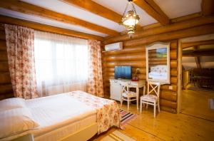 a bedroom with a bed and a desk and a television at Conacul Maria Theresa in Orlat