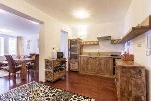 a kitchen with wooden cabinets and a dining room at Apartment SnowWhite in Starý Smokovec