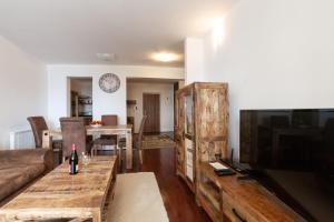 a living room with a couch and a television at Apartment SnowWhite in Vysoke Tatry - Stary Smokovec