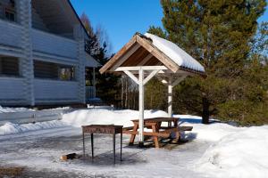 a picnic table and a umbrella in the snow at Eco Hotel Noviy Kovtcheg in Gorodets