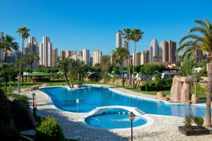 a large swimming pool with a city in the background at Camping Villasol in Benidorm