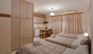 una camera con due letti e una cucina con tavolo di Tsironis Guesthouse a Ioannina