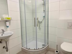 a shower with a glass door next to a toilet at Checkinn Hotel in Bad Salzuflen
