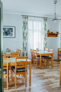 a dining room with wooden tables and chairs at Villa Sopocka in Sopot