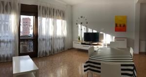 a living room with a table and chairs and a television at Apartamento Centro Historico Teruel in Teruel