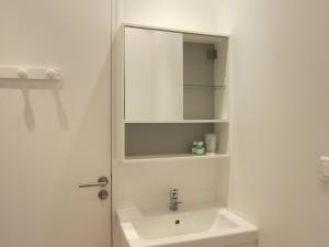 a white bathroom with a sink and a mirror at Le COURLIS vue panoramique sur la mer, balcons in Ault