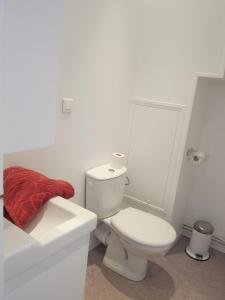 La salle de bains blanche est pourvue de toilettes et d'un lavabo. dans l'établissement Le COURLIS vue panoramique sur la mer, balcons, à Ault
