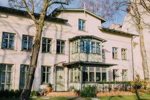 a large white house with blue windows at Villa Sopocka in Sopot