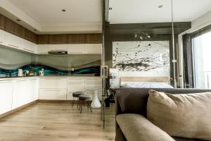 a living room with a couch and a kitchen at Kapart Rzeszów Apartment in Rzeszów