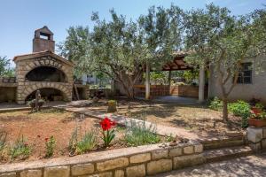 a garden in front of a building with a stone wall at Anka in Nerezine