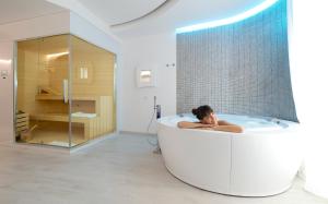 a person in a bath tub in a bathroom at AHD Rooms in Milan