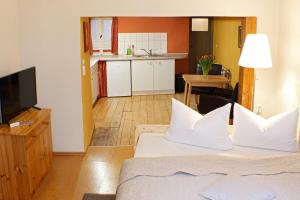 クヴェードリンブルクにあるFerienwohnung Im Dammのリビングルーム(ベッド1台付)、キッチンが備わります。