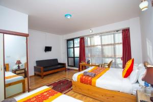a bedroom with two beds and a living room at The Boudha Inn in Kathmandu