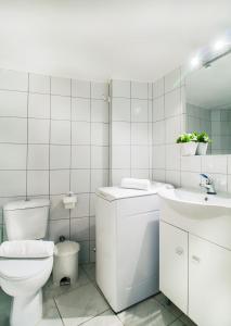 uma casa de banho branca com um WC e um lavatório em Stylish apartment next to Thiseio and Keramikos em Atenas